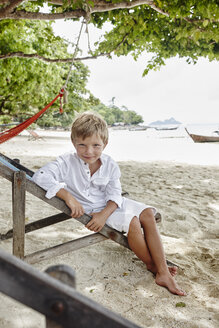 Thailand, Phi Phi-Inseln, Ko Phi Phi, Porträt eines Jungen auf einem Liegestuhl am Strand - RORF01097