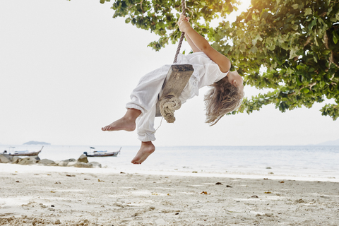 Thailand, Phi Phi Islands, Ko Phi Phi, little girl on a rope swing on the beach stock photo