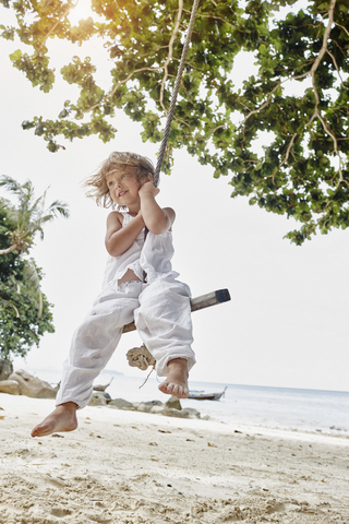 Thailand, Phi Phi Islands, Ko Phi Phi, smiling little girl on a rope swing on the beach stock photo