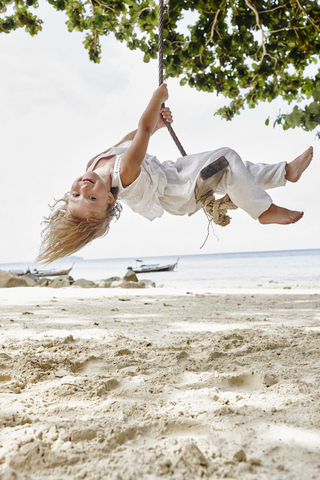 Thailand, Phi Phi Islands, Ko Phi Phi, happy little girl on a rope swing on the beach stock photo