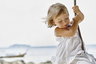 Thailand, Phi Phi Islands, Ko Phi Phi, happy little girl on a rope swing on the beach - RORF01107