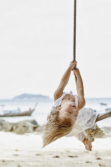 Thailand, Phi Phi Inseln, Ko Phi Phi, glückliches kleines Mädchen auf einer Seilschaukel am Strand - RORF01109