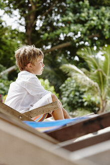 Thailand, Phi Phi Inseln, Ko Phi Phi, Junge sitzt auf Liegestuhl am Strand - RORF01110