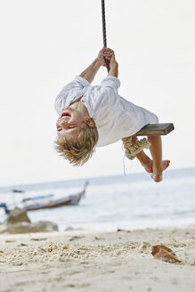 Thailand, Phi Phi Islands, Ko Phi Phi, happy boy on a rope swing on the beach - RORF01112