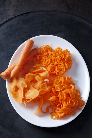Whole and spiralized carrots on plate stock photo