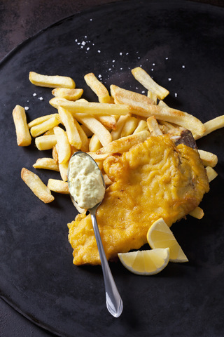 Fish and chips with remoulade and lemon slice stock photo