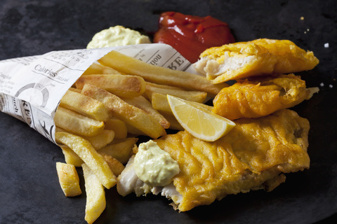 Fish and chips with remoulade, ketchup and lemon slice stock photo