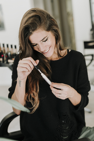 Laughing young woman applying Makeup stock photo