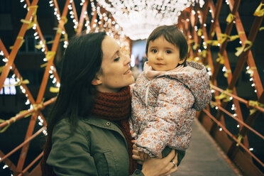 Mutter und kleines Mädchen auf einer Brücke mit Lichtern zu Weihnachten - GEMF01851