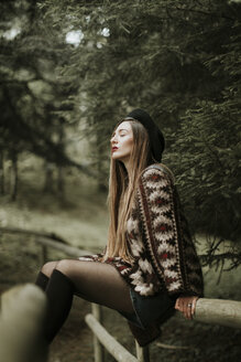 Modische junge Frau beim Entspannen im Wald - OCAF00086