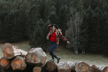 Young woman balancing on logs - OCAF00092