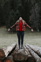 Junge Frau balanciert auf Baumstämmen - OCAF00094