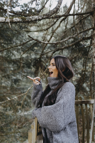 Überrascht junge Frau auf einem Baumhaus in der Natur, lizenzfreies Stockfoto
