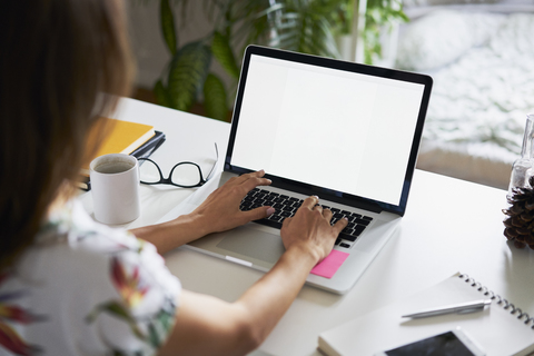 Young woman working at desk with laptop stock photo