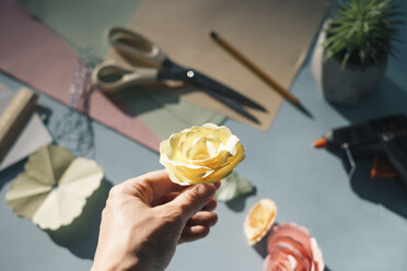 Female hand holding a paper rose - MOMF00378