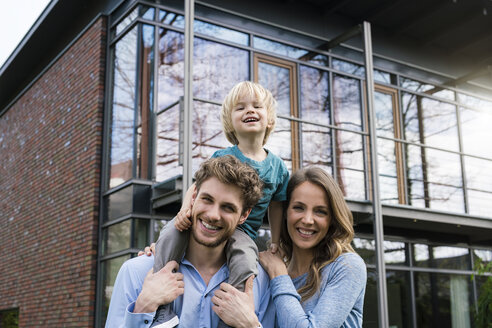 Porträt von lächelnden Eltern mit Sohn vor ihrem Haus - SBOF01312