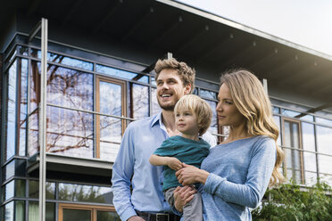 Smiling parents with son in front of their home - SBOF01314