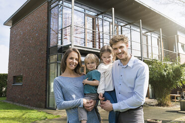 Portrait of smiling family in front of their home - SBOF01323