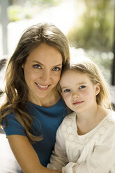 Portrait of smiling mother with daughter in front of window - SBOF01349