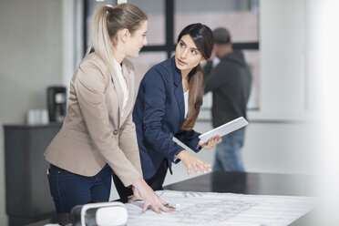 Two young women with tablet and VR glasses working on blueprint in office - ZEF14910