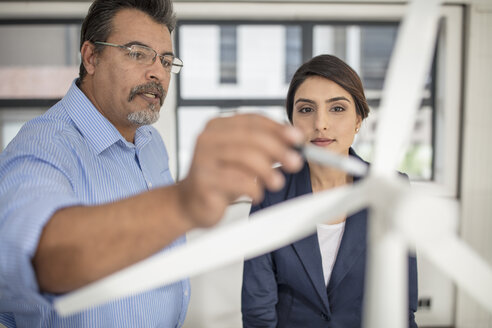 Colleagues discussing wind turbine model in office - ZEF14921