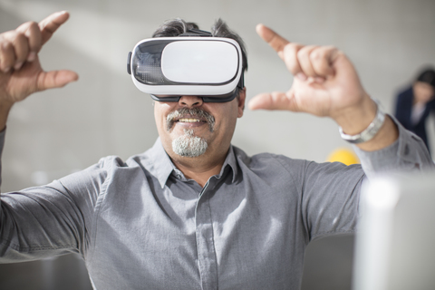 Man wearing VR glasses in office stock photo