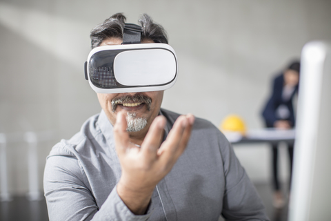 Man wearing VR glasses in office stock photo