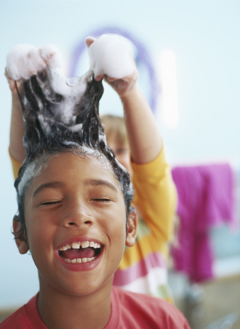 Porträt eines lachenden kleinen Jungen mit Schaum in den Haaren, lizenzfreies Stockfoto