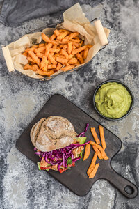 Veganer Jackfruit-Burger mit Süßkartoffelpommes und Guacamole, gehobener Blick - SARF03518