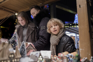 Porträt eines Jungen auf dem Weihnachtsmarkt mit seinen Eltern - KMKF00147