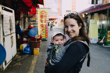 Südkorea, Mutter und kleines Mädchen in einer Babytrage in Busan - GEMF01866