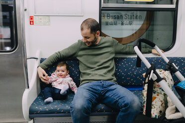 South Korea, Busan, father and baby girl traveling by subway with a stroller - GEMF01868