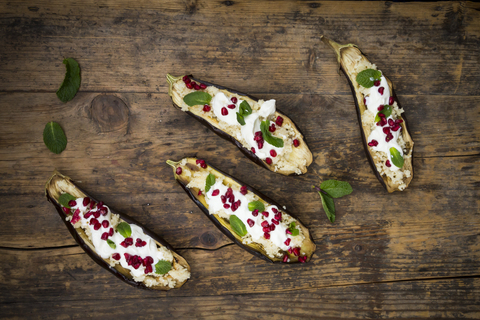 Gefüllte Aubergine, Couscous, Joghurtsauce, Minze und Granatapfelkerne, lizenzfreies Stockfoto