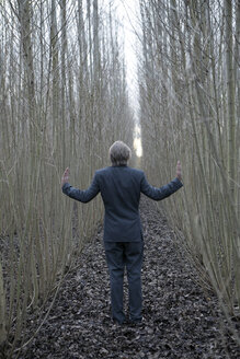 Businessman standing amidst willows - PSTF00065