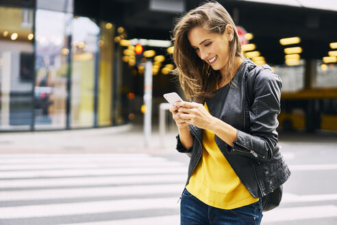 Happy woman looking at cell phone - BSZF00204