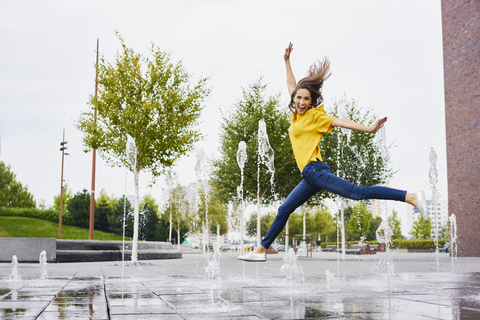 Happy young woman jumping in the air stock photo
