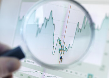 Investor analysiert Liniendiagramm auf Computerbildschirm mit Lupe - ABRF00071