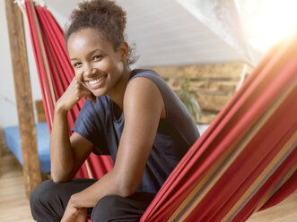 Portrait of happy young woman sitting in hammock - MADF01397