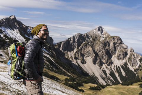 Österreich, Tirol, lächelnder junger Mann auf einer Wanderung in den Bergen, lizenzfreies Stockfoto