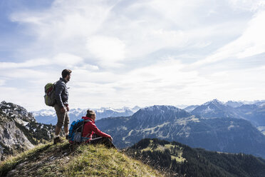 Austria, Tyrol, young couple in mountainscape looking at view - UUF12563