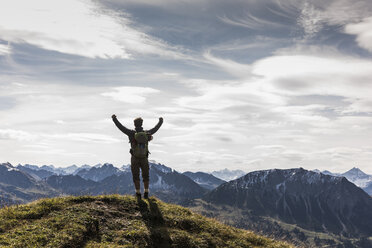 Austria, Tyrol, young man standing in mountainscape cheering - UUF12566