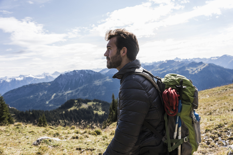 Österreich, Tirol, junger Mann in Berglandschaft mit Blick auf die Aussicht, lizenzfreies Stockfoto