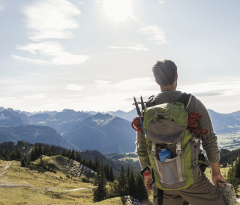 Österreich, Tirol, junger Mann in Berglandschaft mit Blick auf die Aussicht, lizenzfreies Stockfoto