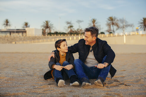 Lächelnder Vater, der seinen Sohn am Strand umarmt - EBSF02018