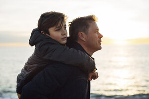 Vater trägt Sohn huckepack am Meer - EBSF02022