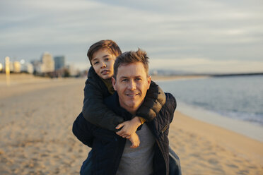 Porträt eines Vaters, der seinen Sohn am Strand huckepack trägt - EBSF02025