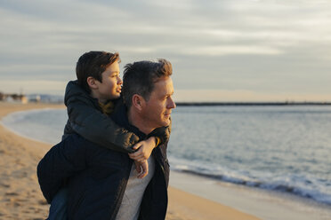Father carrying son piggyback on the beach - EBSF02026