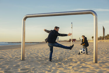 Father and son playing football on the beach - EBSF02039