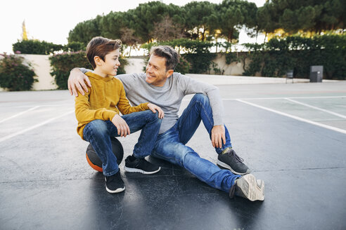Vater umarmt Sohn auf Basketballplatz im Freien - EBSF02066