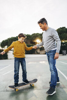 Vater hilft seinem Sohn beim Skateboardfahren - EBSF02074